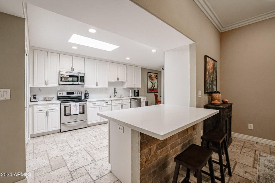 Beautifully updated kitchen with quartz counters, breakfast bar and eat in breakfast room.