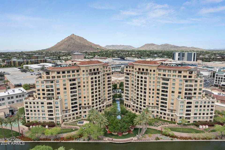 Exterior view of the prestigious Scottsdale Waterfront Residences showcasing luxury architecture, beautifully landscaped grounds, and panoramic Camelback Mountain views. Enjoy upscale high-rise living just steps from premier shopping, dining, and entertainment.