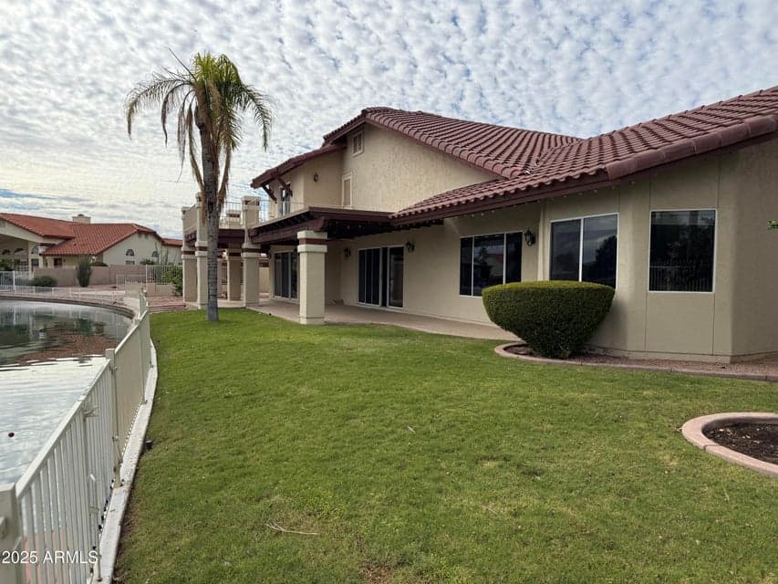 Back of the house with large covered patio and a view of the lake from every angle
