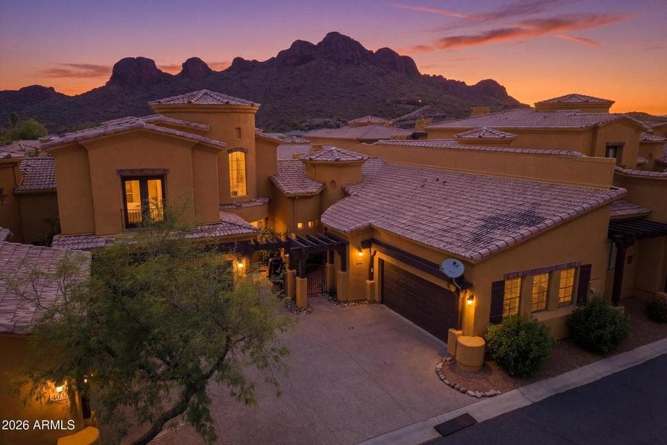 Twilight aerial showcasing the home’s exterior with warm evening lighting.