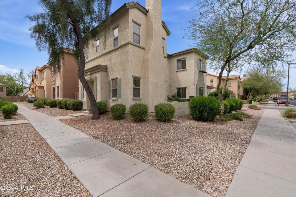 Front exterior of this two-story home in Surprise featuring attractive desert landscaping, mature trees, and inviting curb appeal. Enjoy low-maintenance landscaping and a welcoming neighborhood close to shopping, dining, parks, and community amenities.