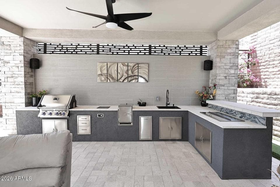 Custom outdoor kitchen with built-in BBQ grill, beverage storage, sink, and extensive prep space designed for entertaining. This Fountain Hills luxury property showcases premium outdoor living and modern resort-style amenities.