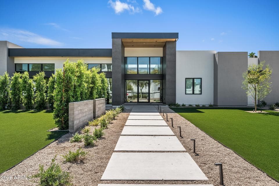 Close-up of the striking modern façade featuring clean lines, large windows, and a grand covered entry. This Paradise Valley property showcases contemporary architecture and exceptional curb appeal.