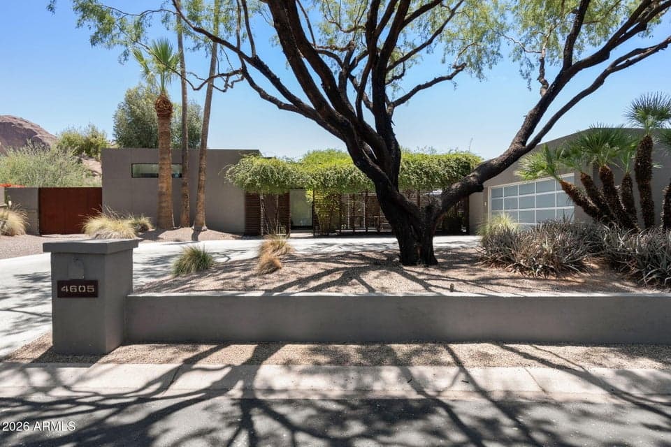 The impressive front elevation showcases sophisticated modern design, lush desert landscaping, and a private gated entry. Located in one of Phoenix's most desirable neighborhoods, this home offers exceptional privacy, contemporary styling, and timeless curb appeal.