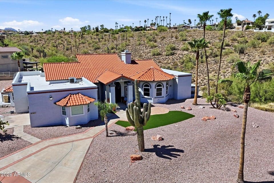 An elevated aerial perspective highlights the home's premier half-acre hillside setting in Fountain Hills, surrounded by scenic desert landscapes, mature saguaros, and towering palms.