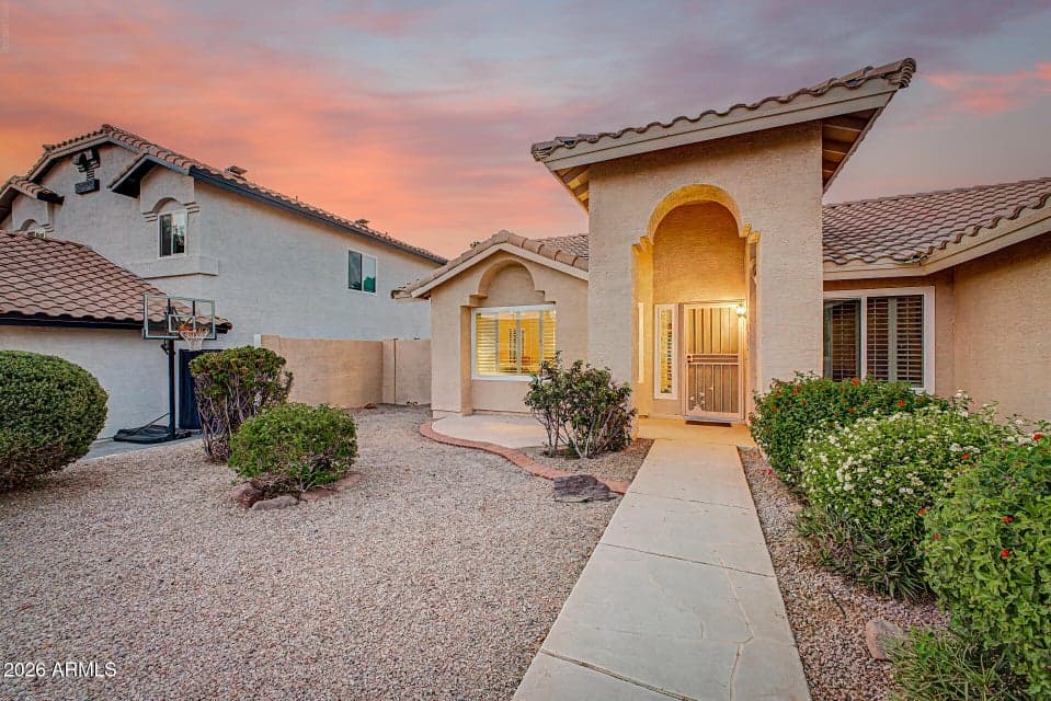 An elegant covered entrance with soaring architectural details creates a warm first impression and invites you into this beautifully maintained home.