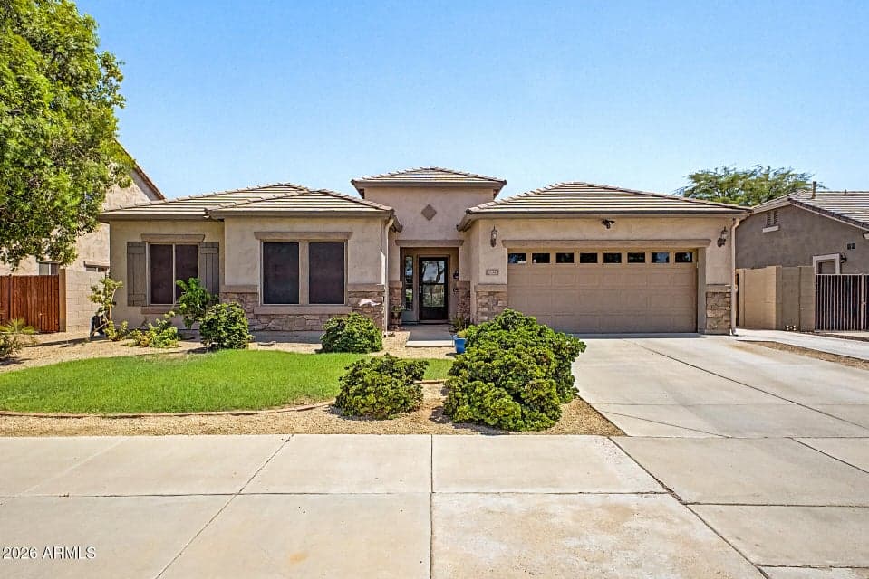 Beautiful front elevation showcasing the homes attractive curb appeal, mature landscaping, and 2 car garage and RV gate