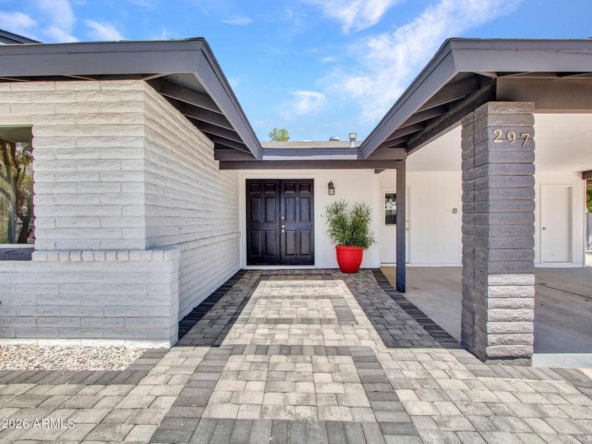 Inviting front entrance featuring a covered patio, updated exterior hardware, fresh paint, and clean lines in an iconic location.