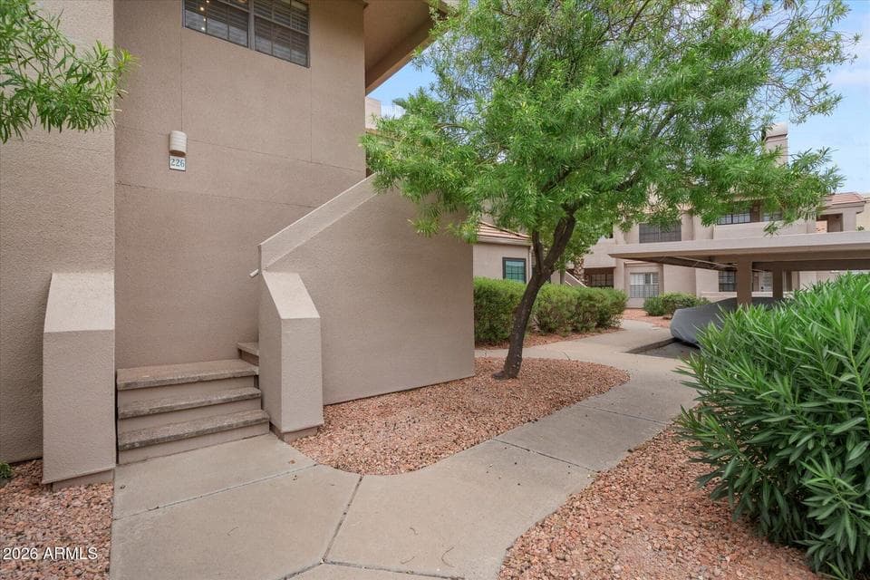 Welcoming Entryway Framed by Vibrant Desert Foliage and Private Staircase