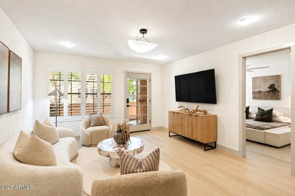 A cozy living room designed to feel like a retreat, with natural light pouring in and views out to the private courtyard—creating an effortless connection between indoor and outdoor living.