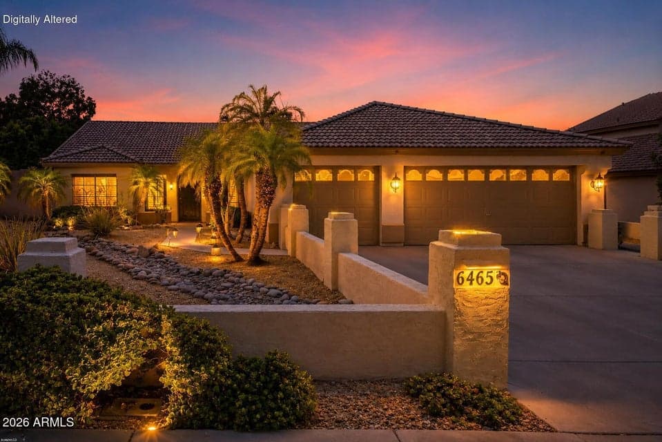 Welcoming single-story exterior with mature palms, desert landscaping, and an oversized three-car garage.