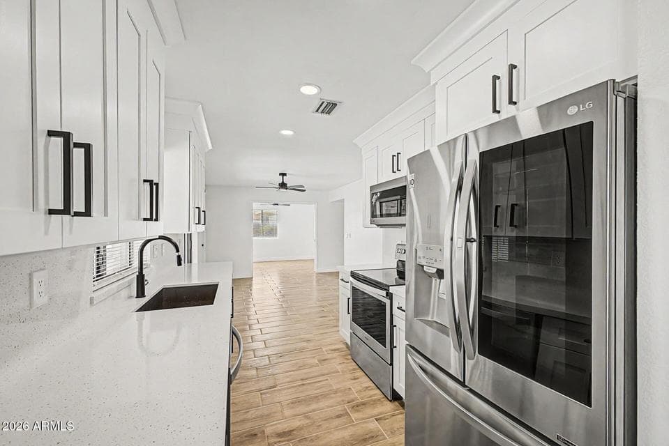 ALL NEW BEAUTIFULLY REMODELED KITCHEN WITH WHITE SHAKER CABINETS, STAINLESS STEEL APPLIANCES, QUARTZ COUNTERTOPS AND BACKSPLASH, BLACK MATTE FINISH FIXTURES AND FINISHES, 5 1/2 INCH BASE BOARDS THROUGHOUT