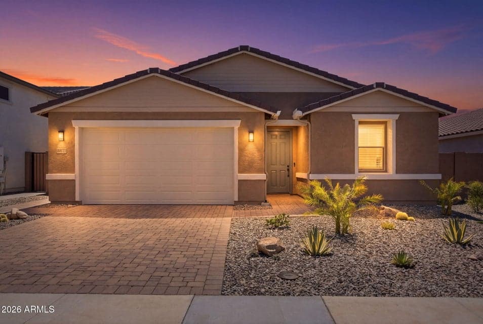 Stunning twilight view showcasing the home’s beautiful curb appeal, paver driveway and walkway, professional landscaping and welcoming exterior lighting.