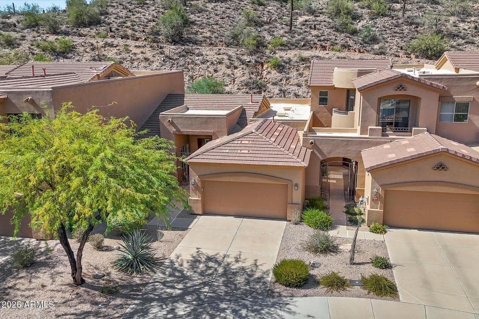 Elevated view showcasing this charming 2-bedroom, 2-bath townhouse nestled against scenic desert hillside terrain in the coveted La Loma enclave at Eagle Mountain.