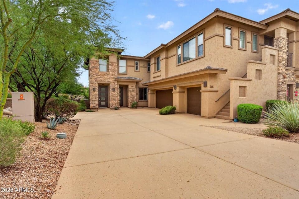 Entrance surrounded by mature desert landscaping.