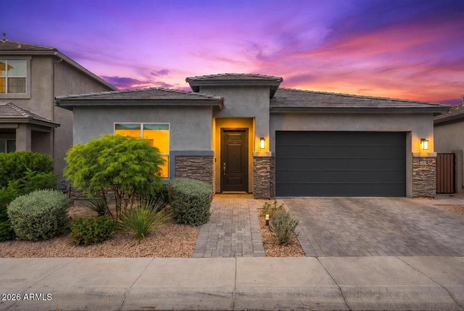Stunning front exterior comes alive at twilight with a dramatic sky, stacked stone accents, and warm landscape lighting. This move-in ready Desert Ridge home offers exceptional curb appeal that makes an unforgettable first impression.