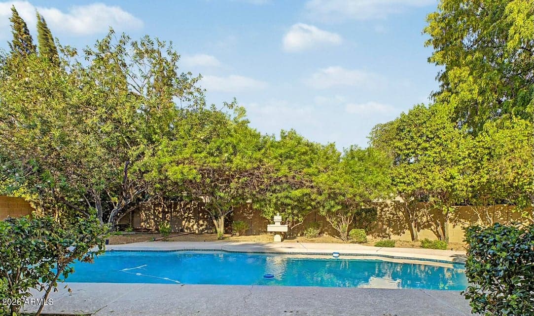 Lush landscaping surrounds pool