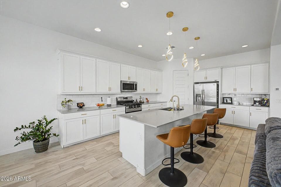 Lovely white cabinets, SS appliances, chef's island, pendant lighting and recessed lighting