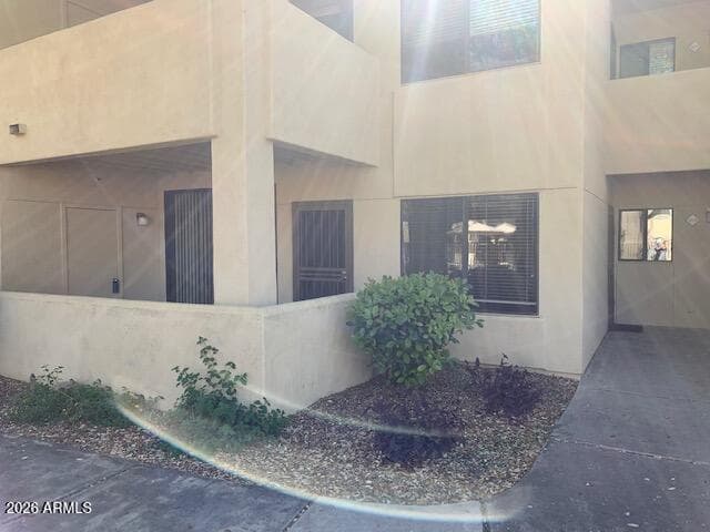 Entry walkway with patio to left and entry straight ahead. Windows in Living Room & Kitchen.