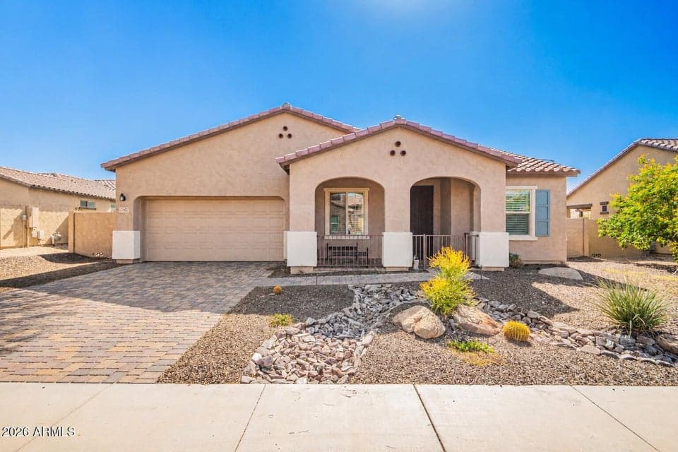 Front of house. Paver driveway, covered patio.