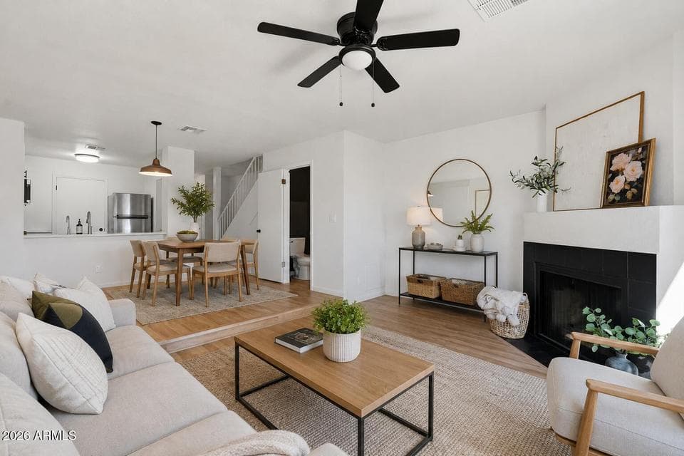 Neutral LVP flooring, wood burning fireplace, matte black ceiling fan, breakfast bar, space for a dining table, and powder bathroom. **Virtual Staging Added.