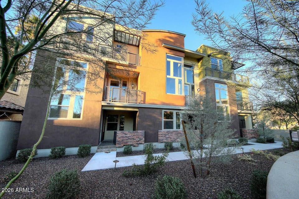 Stunning 3-story contemporary facade with multi-tone stucco, private balconies, and brick accents.