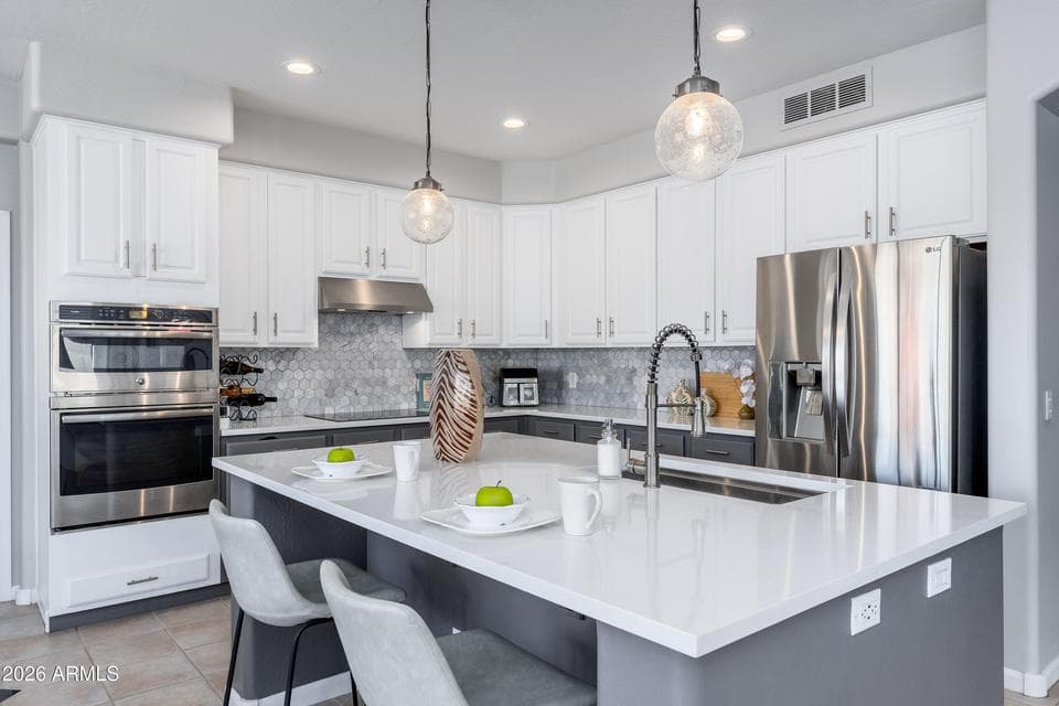 Large island, refinished cabinets, quartz counters and decorative backsplash