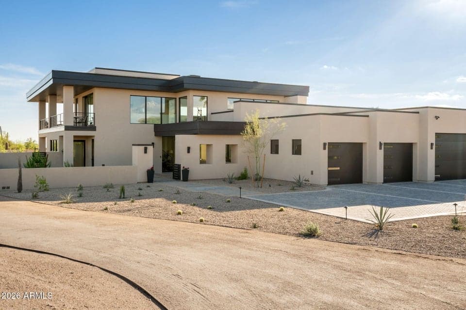 Contemporary desert architecture stretches across a broad front elevation, framed by open desert