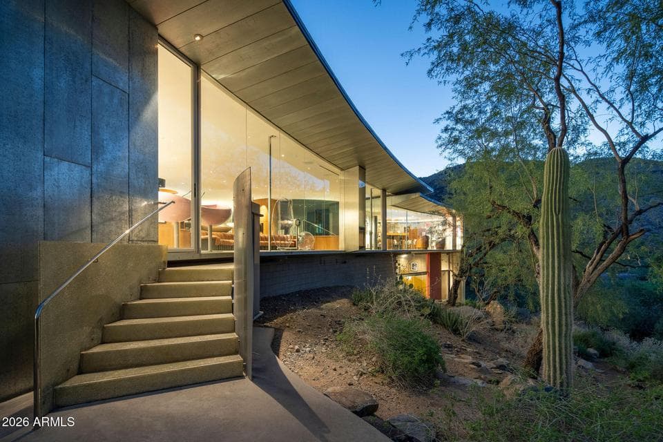 A crescent shaped arc of floor to ceiling glass forms the back wall of this Will Bruder, FAIA designed property.