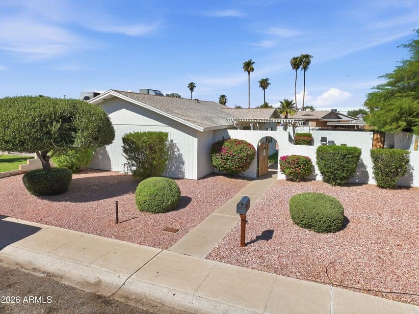 Single-story residence with desert landscaping and gated courtyard entry.